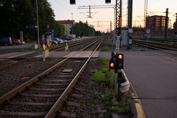 Traffic light shows red signal on railway in the nightfall.
