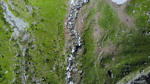 Aerial: drone flying over scenic high waterfall lush green valley and mountain stream on the italian Alps. Tourism destination hiking outdoors activity. Pis waterfall near Torino, Piedmont, Italy