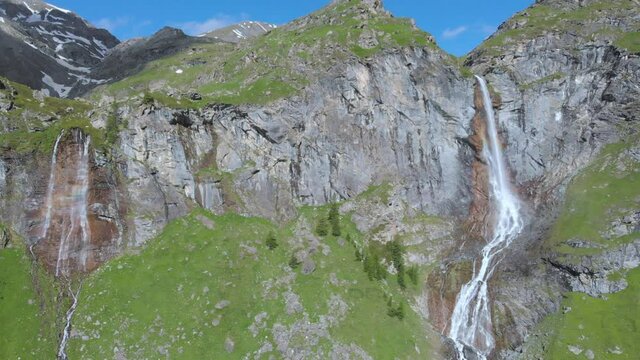 Aerial: drone flying over scenic high waterfall lush green valley and mountain stream on the italian Alps. Tourism destination hiking outdoors activity. Pis waterfall near Torino, Piedmont, Italy