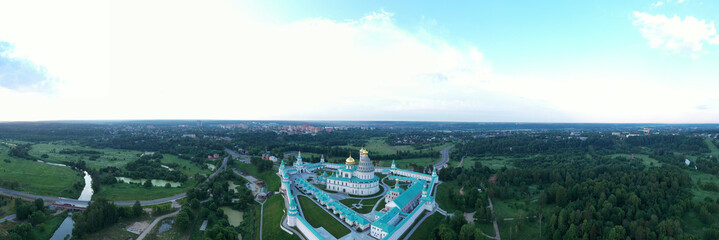 panoramic views of the old white stone monastery standing on a green hill filmed from a drone