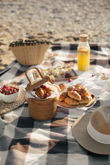 Beautiful cozy summer picnic with lemonade, fresh bread and fruits on a beach.