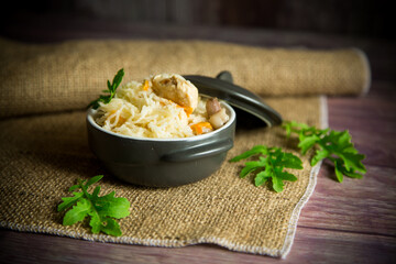 boiled rice with vegetables and meat in a ceramic bowl on a wooden table