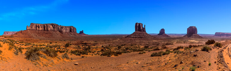 A panorama view showing Elephant Butte, East and West Mitten Buttes in Monument Valley tribal park in springtime