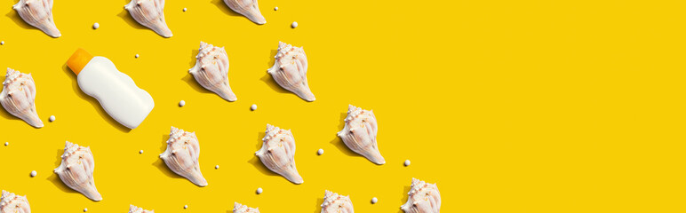 Sunblock bottle with seashells with shadow - flat lay