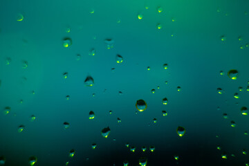 Abstract background with drops on glass of green window.
