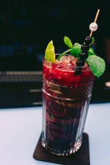Fresh Berries Juice summer ice cold black currant Cocktail with Sweet decoration slice Author Drink - on bar counter . Close-up Top view . Copy paste space design barman people and luxury nightclub
