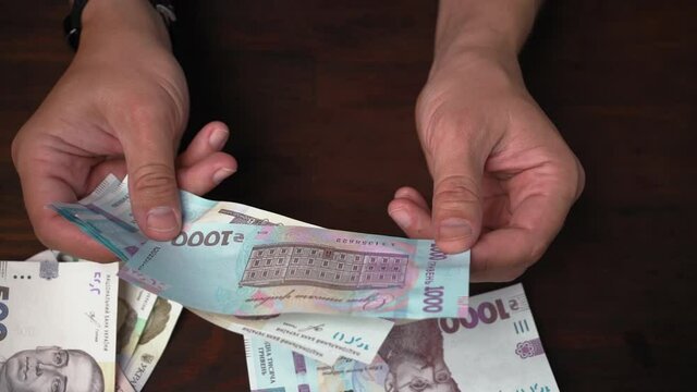 Man considers new Ukrainian paper money. Male hands holding pack of banknotes face value 1000 hryvnia. Close up shot. Prores 422. 