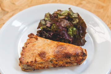 piece of pie on a plate and salad