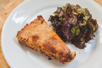 piece of pie on a plate and salad