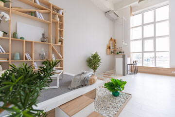Luxury fashionable modern design studio apartment with a free layout in a minimal style. very bright huge spacious room with white walls and wooden elements. sitting area with fireplace