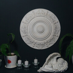 Gypsum alabaster round classical wall decoration rosette, some candles, plants and sculpture of...
