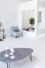 Luxury fashionable modern design studio apartment with a free layout in a minimal style. very bright huge spacious room with white walls and wooden elements. sitting area with fireplace