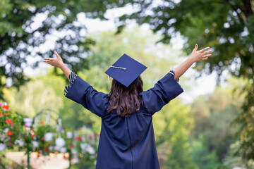 Happy young woman graduating with hands up