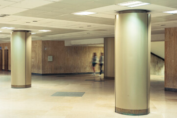Motion blurred persons coming out of the subway station in an underground pedestrian passage.