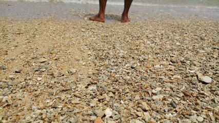 Men legs on the beach.Male foot on the sand beach.Half bottom body shot on beach.