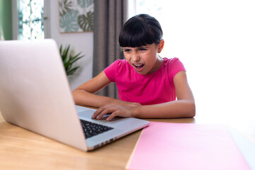 girl watching something disgusting her on a computer at home