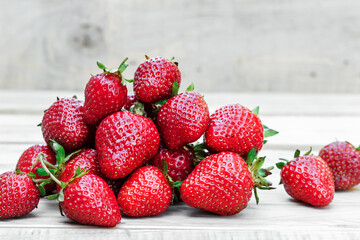 Berries of ripe juicy strawberries on a wooden background. A lot of strawberries lies on wooden boards. Free space on the image.