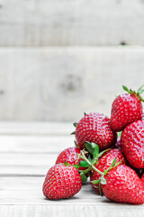 Berries of ripe juicy strawberries on a wooden background. A lot of strawberries lies on wooden boards. Free space on the image.