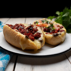 Mexican molletes with chorizo and fresh sauce on white background
