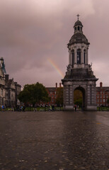 The campanile of Trinity College in Dublin capital of Ireland on cloudy day with rainbow background. 