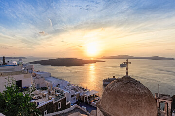 A wonderful and typical scene in Santorini with sunset, clouds, ships and many terraces in Thera