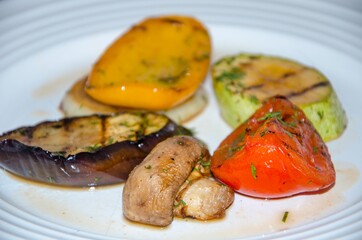 different baked vegetables lie on a plate in a circle