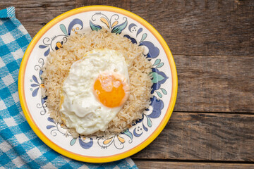 Fried egg with rice on wooden background