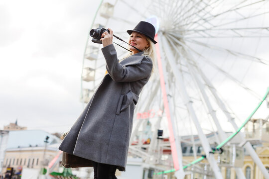 Stylish woman posing near ferris wheel