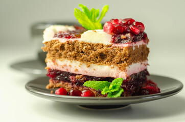 Colorful multi-layered cream chocolate cake with cherry jam and pomegranate