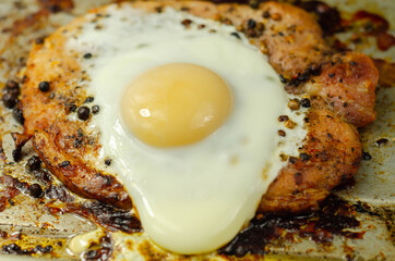 Fried portion of gammon served with egg on the metal plate