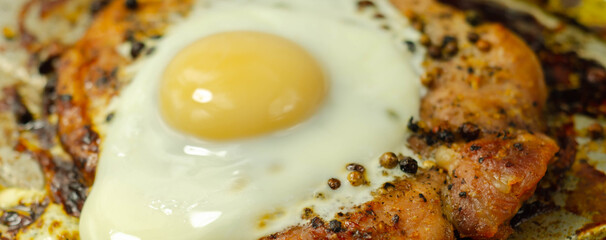 Fried portion of gammon served with egg on the metal plate