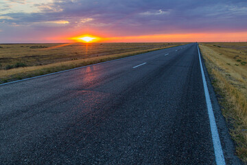 Obraz na płótnie Canvas Sunset view of a road in russian steppe