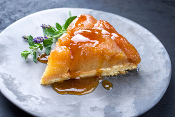 Traditional French tart tatin with apples and vanilla offered as close-up on a modern design plate...