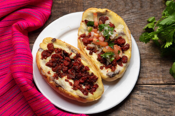 Mexican molletes with chorizo and fresh sauce on wooden background