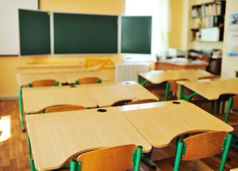 an empty schoolroom, desks, chairs, a green blackboard. The concept of back to school, no people, education.