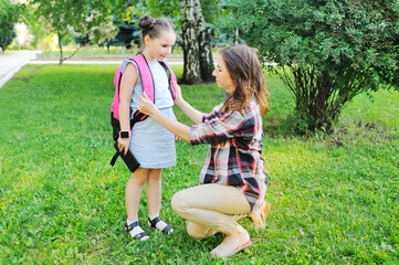 mother dresses and escorts her daughter to school. Back to school, the day of knowledge, education.