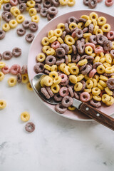 Multi-colored corn rings on a pink plate for breakfast, healthy food.