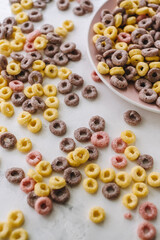 Multi-colored corn rings on a pink plate for breakfast, healthy food.