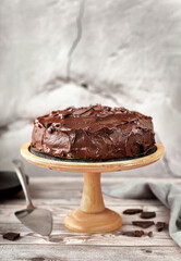 Vegan chocolate cake in a wooden tray against cracked concreat wall