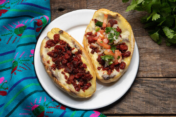 Mexican molletes with chorizo and fresh sauce on wooden background