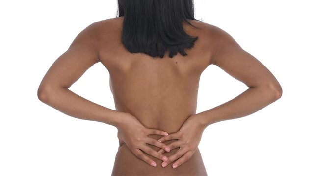 Back view of a black woman having problems with the spine. Osteoporosis leading the back pain. Healthcare concept. Isolated one the white background.