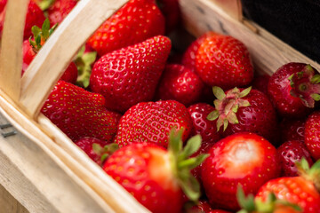 Wooden crate full of ripe strawberries.