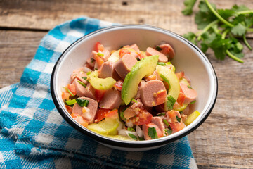 Mexican sausage ceviche with avocado on wooden background
