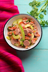 Mexican sausage ceviche with avocado on turquoise background