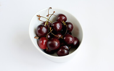 Cherry in a white plate on a white background