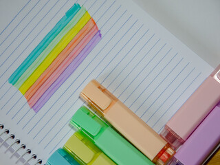 rainbow pastel colors highlighters over a notebook
