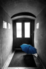 Blue umbreala in old town corridor behind the door