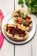 Mexican molletes with chorizo and fresh sauce on white background