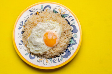 Fried egg with rice on yellow background