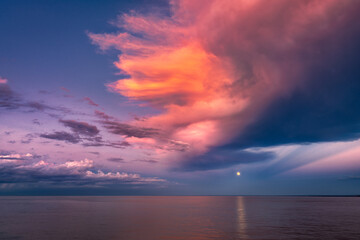 Moon over Sea Horizon with Golden Sunset Clouds